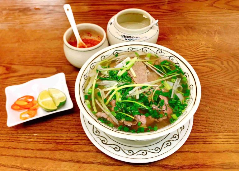 Bowl of Hanoi beef pho with lime and chili - Rose Travel