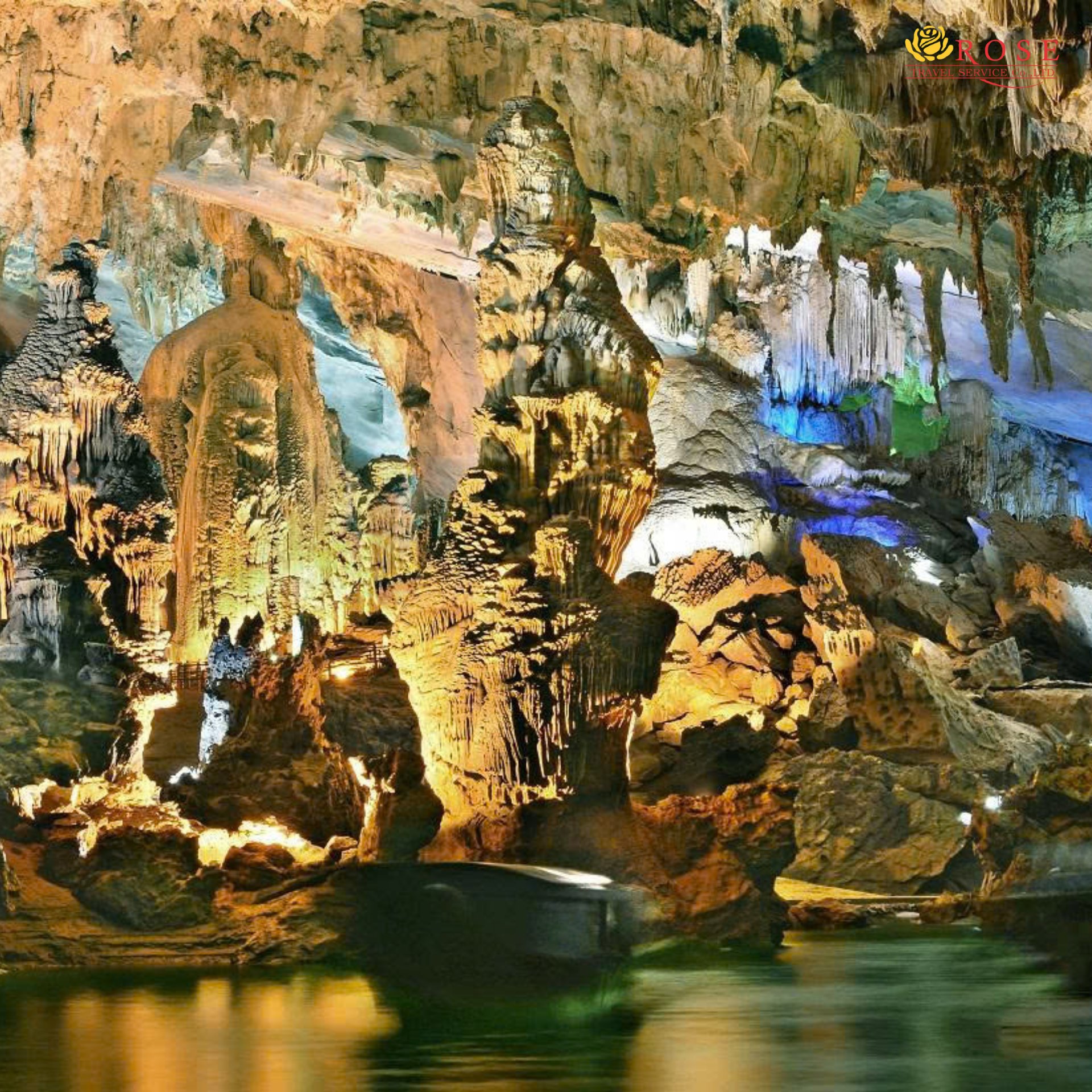 Boat gliding past lit stalactites inside Phong Nha Cave